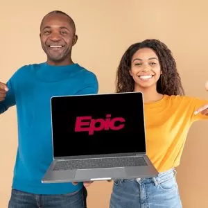 Excited black couple showing laptop with black screen, presenting and pointing at gadget with blank space for mockup Excited black couple holding and showing laptop with black screen, presenting and pointing at gadget with blank space for mockup, peach studio background